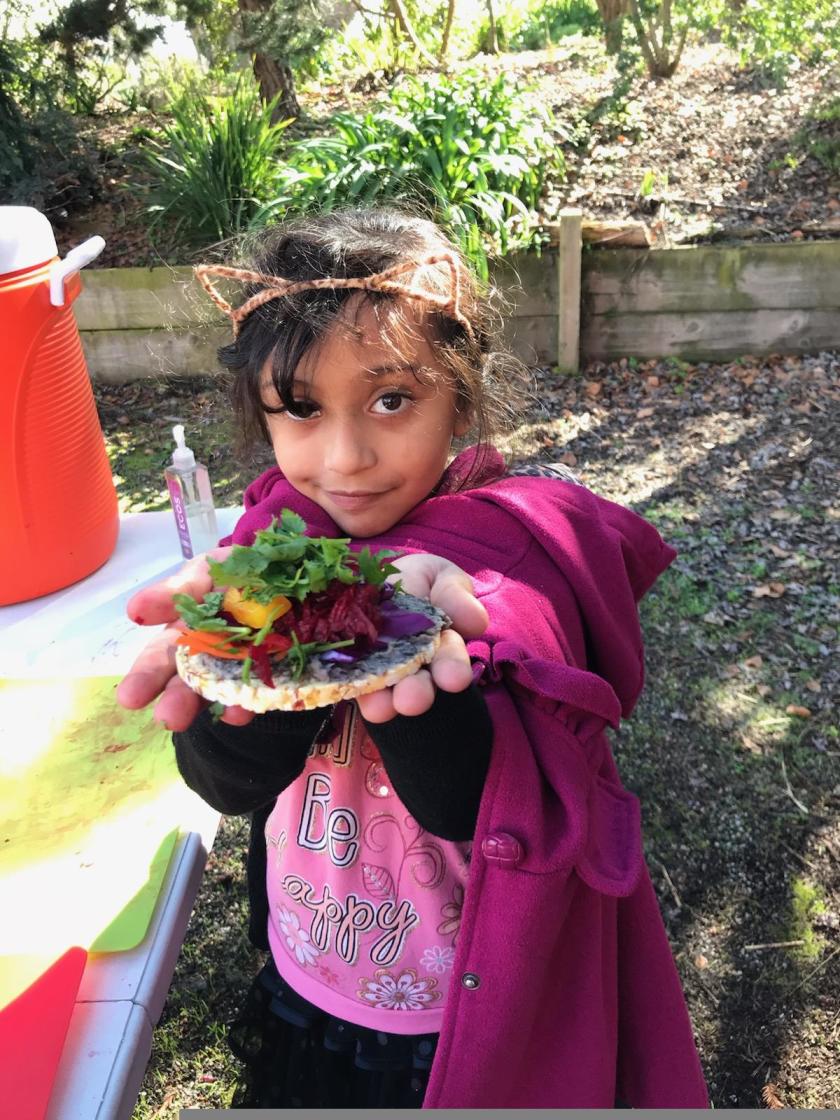 Little girl holding a plate of salad she made