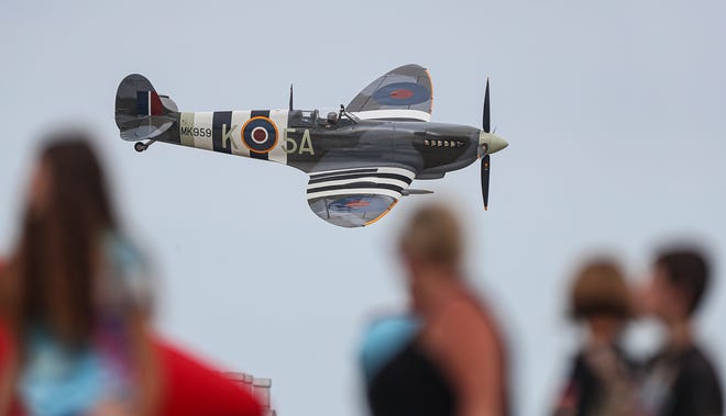 A WWII Spitfire flies by a crowd of people Friday, July 30, 2021 during the 2021 Airventure air show on the EAA grounds in Oshkosh, Wisconsin.