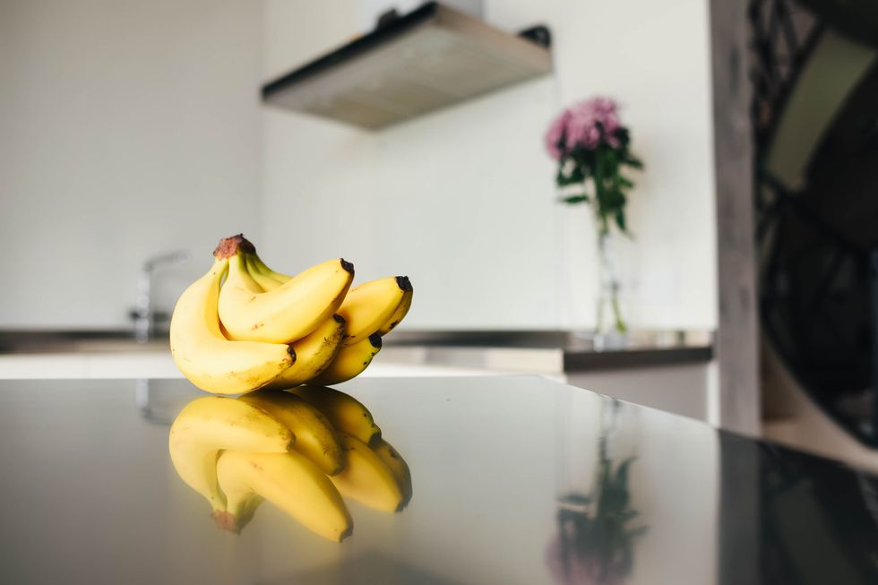 bananas lie on the table against the background of modern kitchen modern kitchen interior in the style of minimalism modern kitchen design